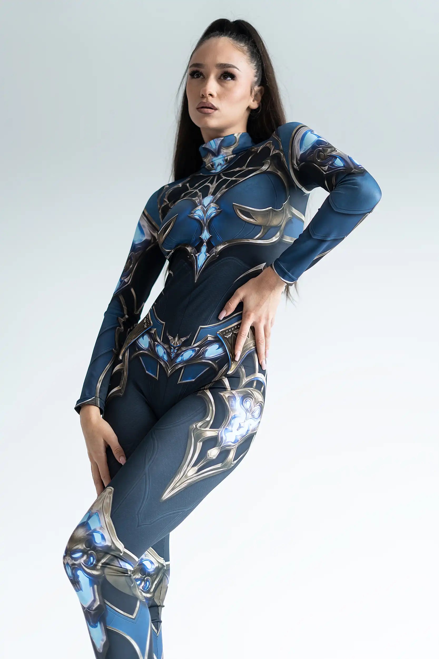 Woman wearing a blue and black patterned outfit on a plain background