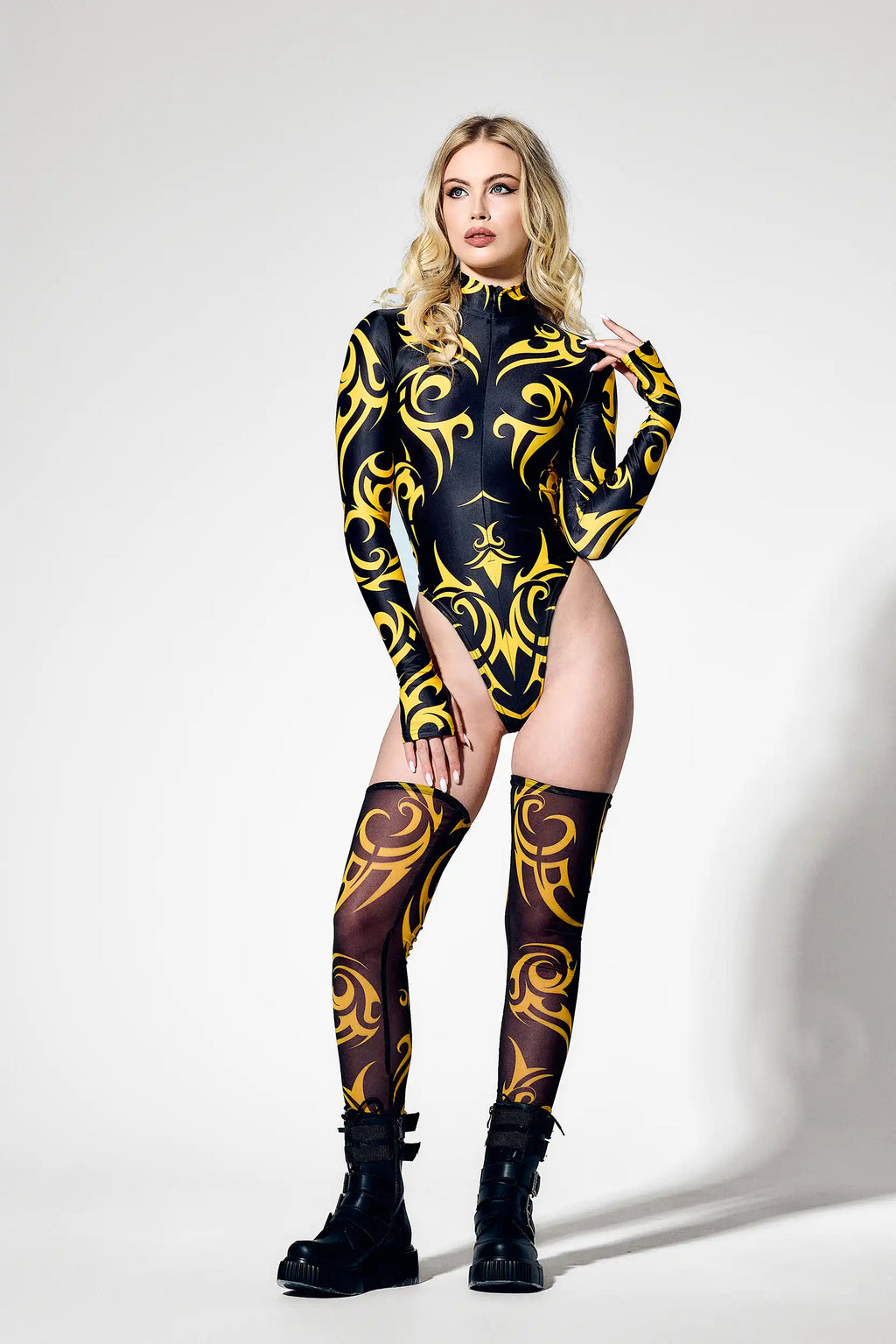 Front view of futuristic black and yellow bodysuit with high neck collar and thumb hole sleeves.