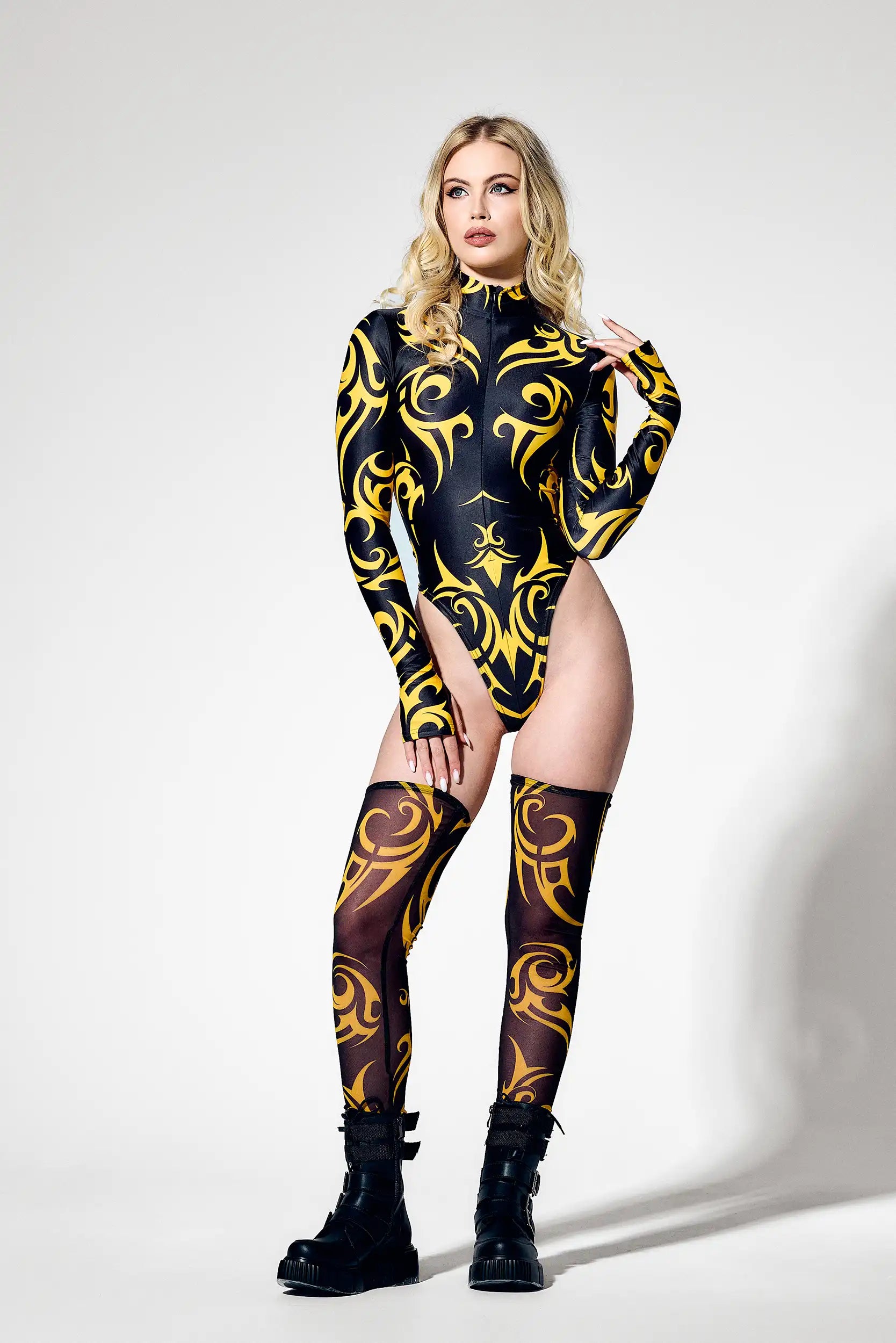 Front view of futuristic black and yellow bodysuit with high neck collar and thumb hole sleeves.