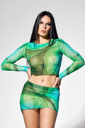 Green Y2K clubwear set styled with platform boots and sheer mesh fabric