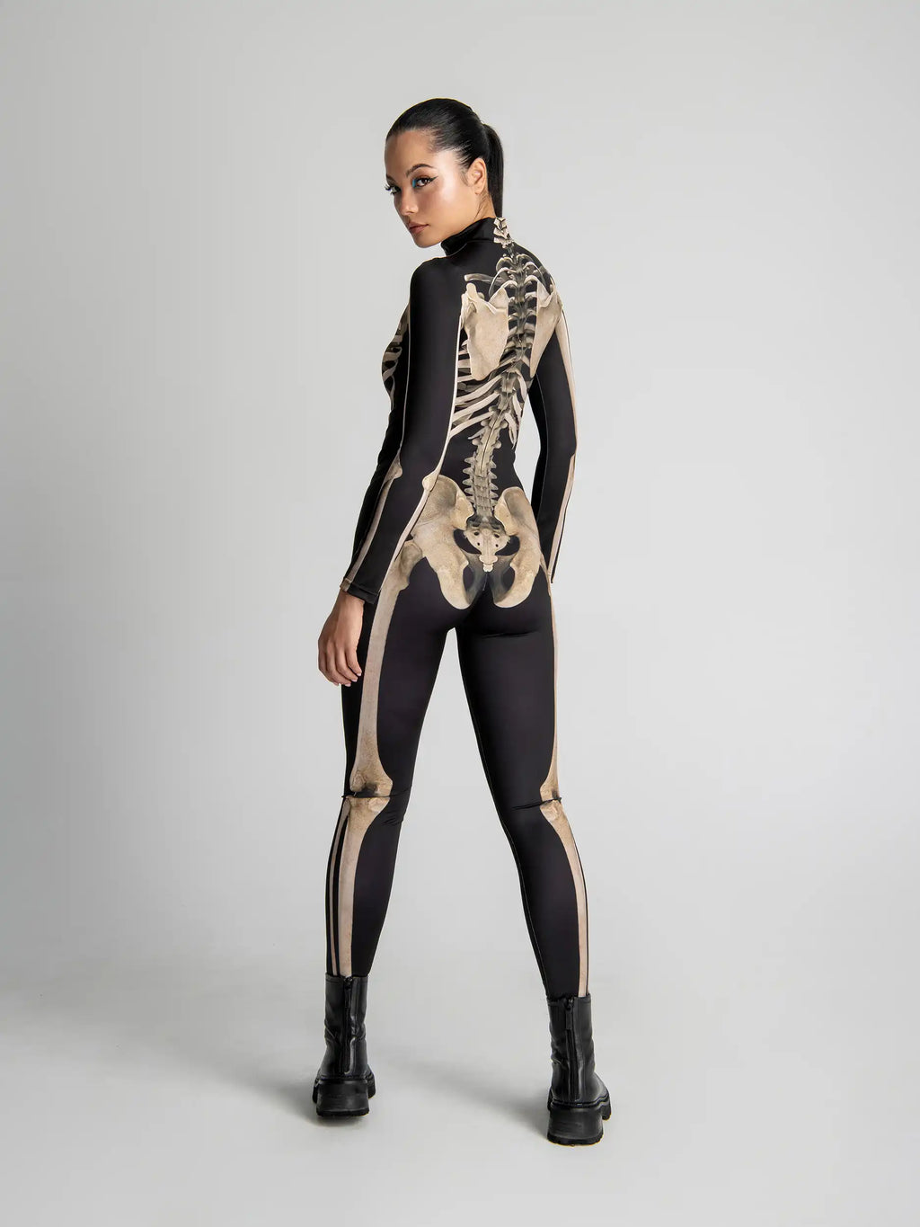 Person wearing a black and beige skeleton-themed bodysuit on a gray background