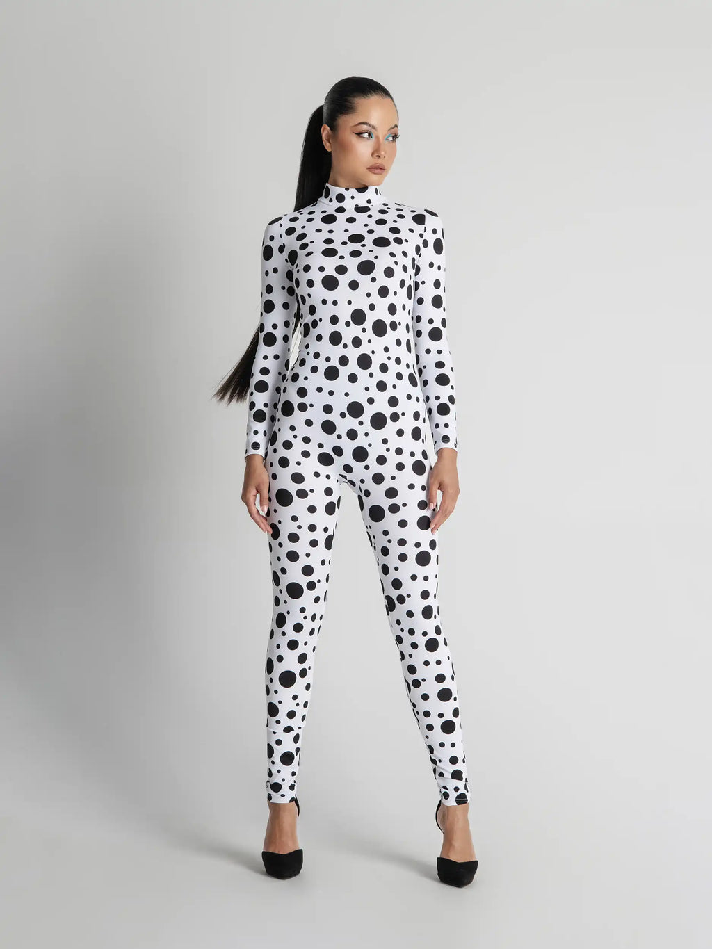 Woman wearing a black and white polka dot outfit on a gray background