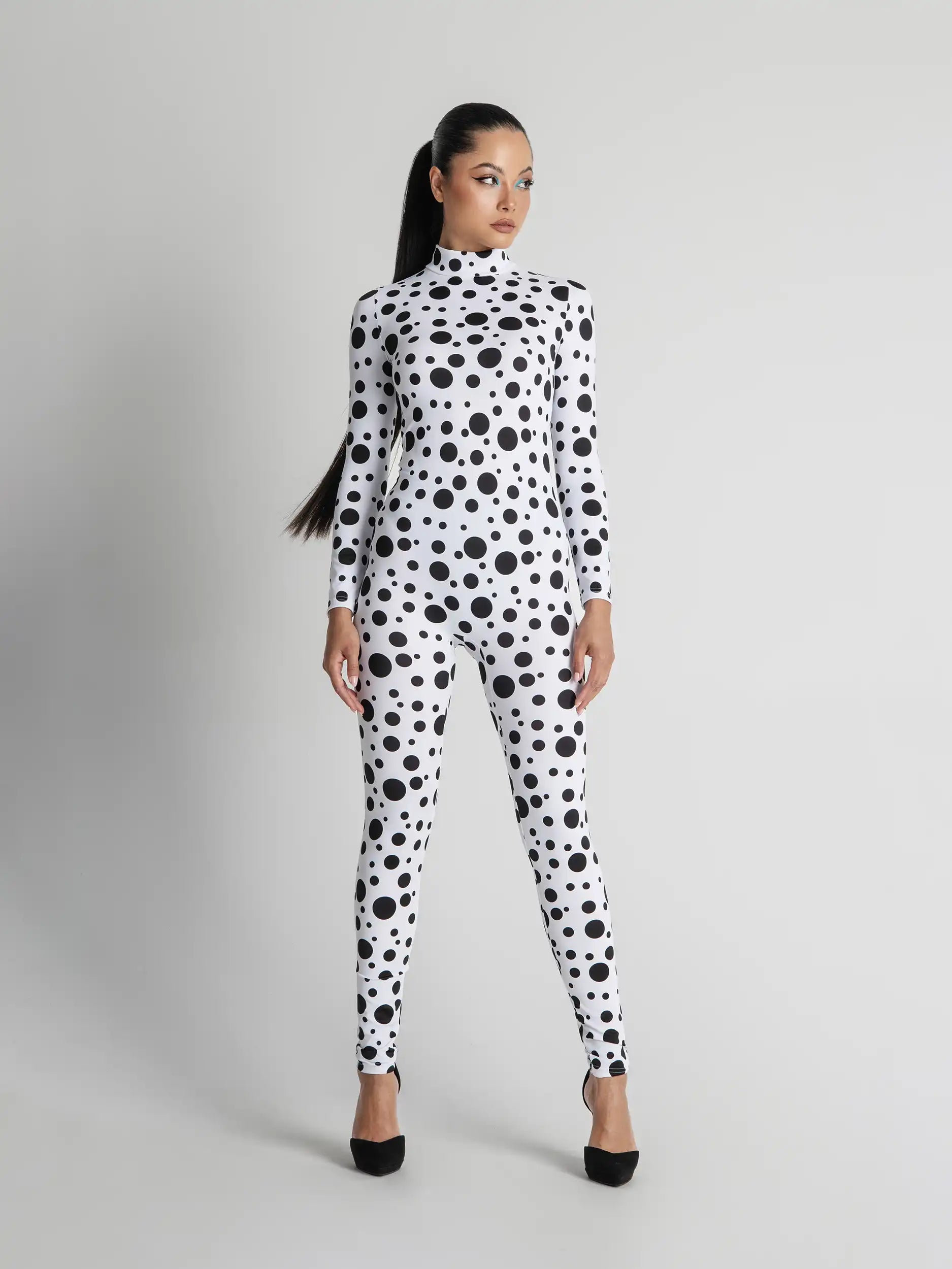 Woman wearing a black and white polka dot outfit on a gray background
