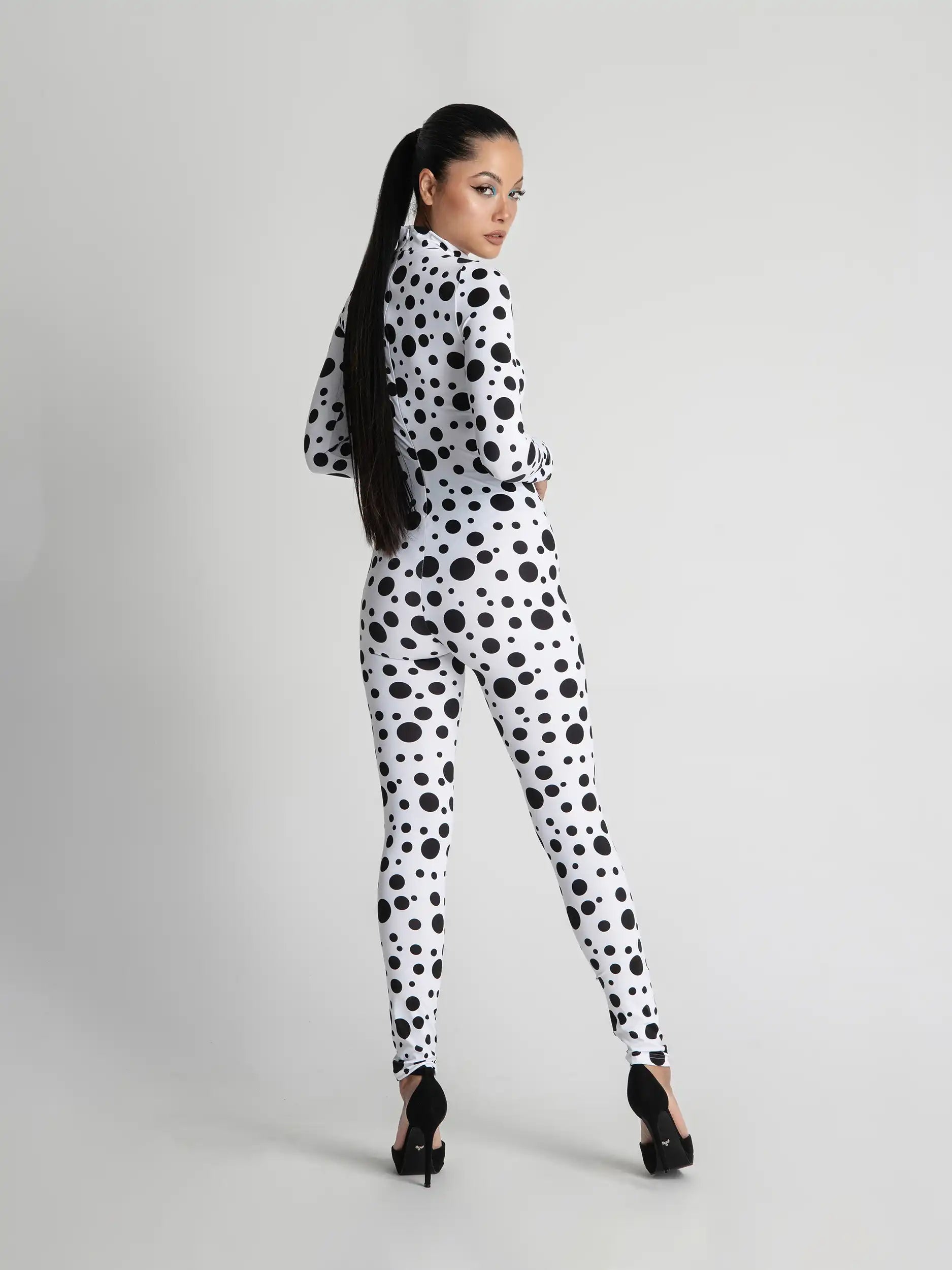 Person wearing a black and white polka dot outfit on a gray background