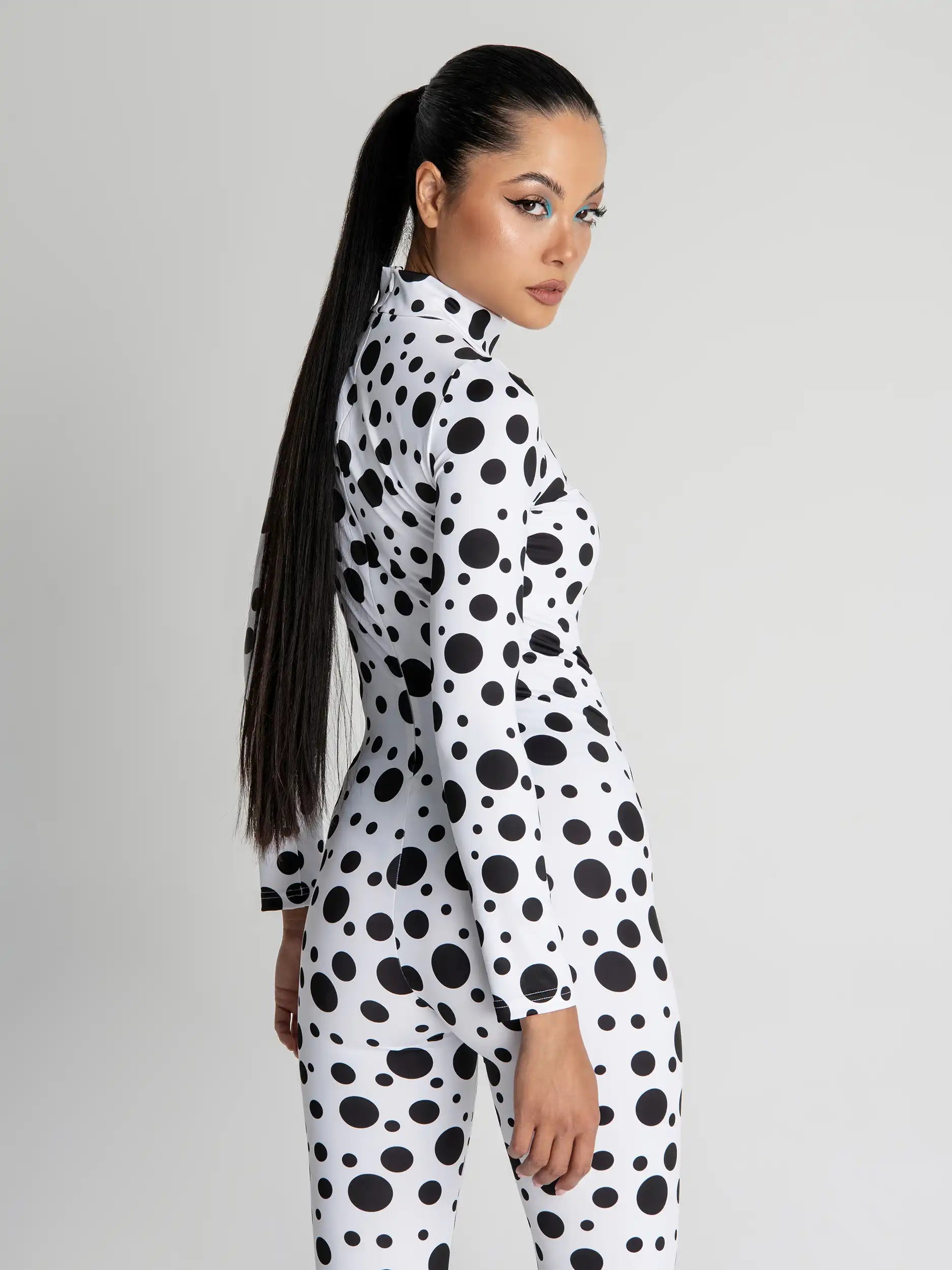 Person wearing a black and white polka dot outfit on a gray background